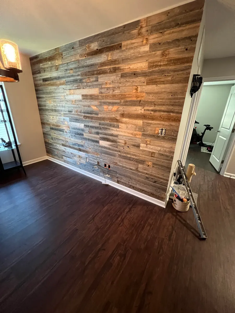 Reclaimed wood accent wall installed across a dining room by Obsidianwise