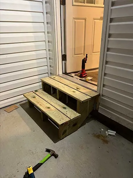 New pressure treated wood steps built at a back door