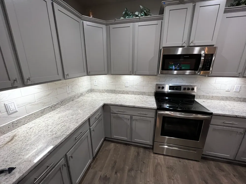 Kitchen backsplash tiled up to the wall units with under cabinet lighting fitted