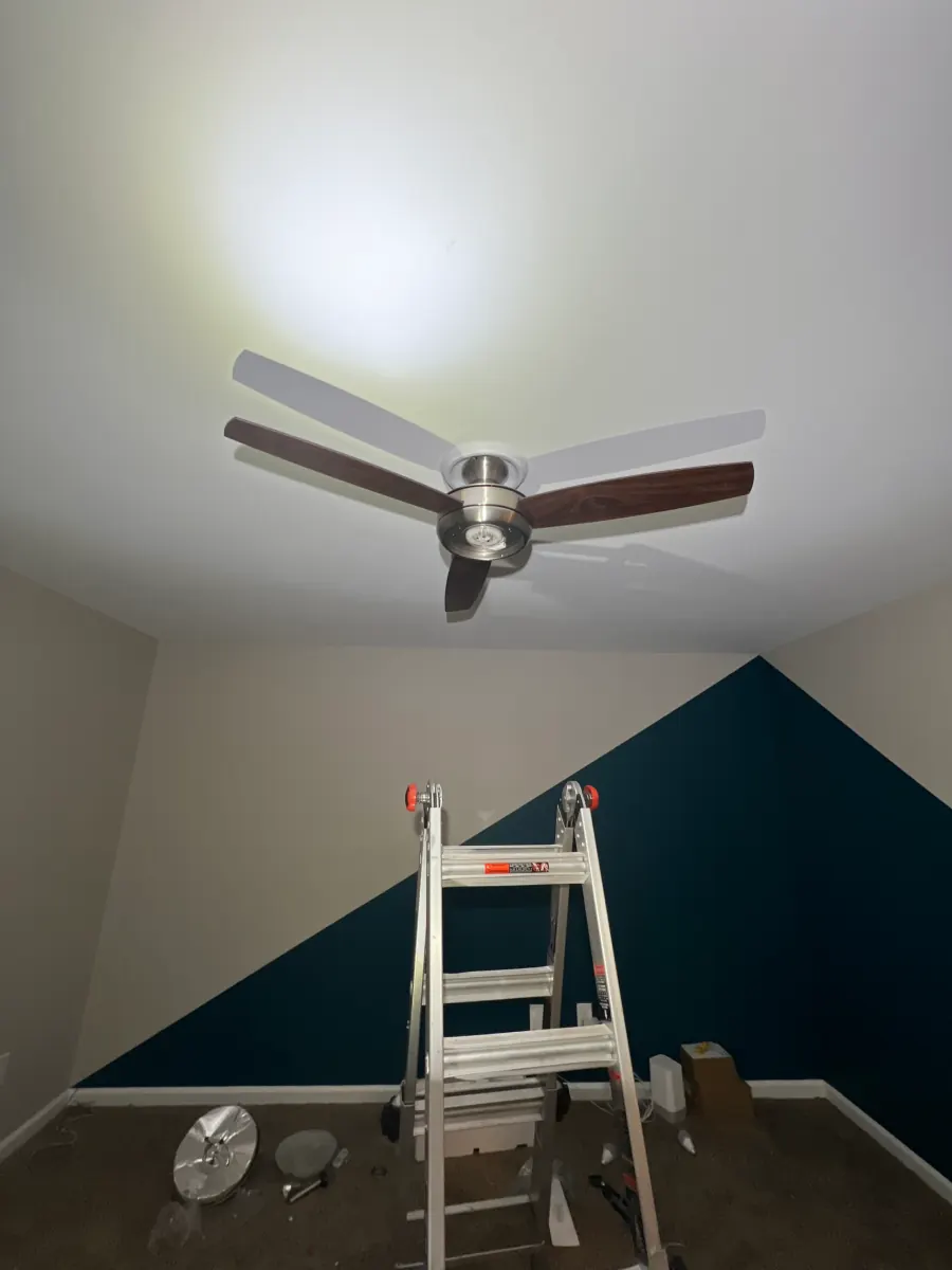 New ceiling fan installed in a room with a blue accent wall