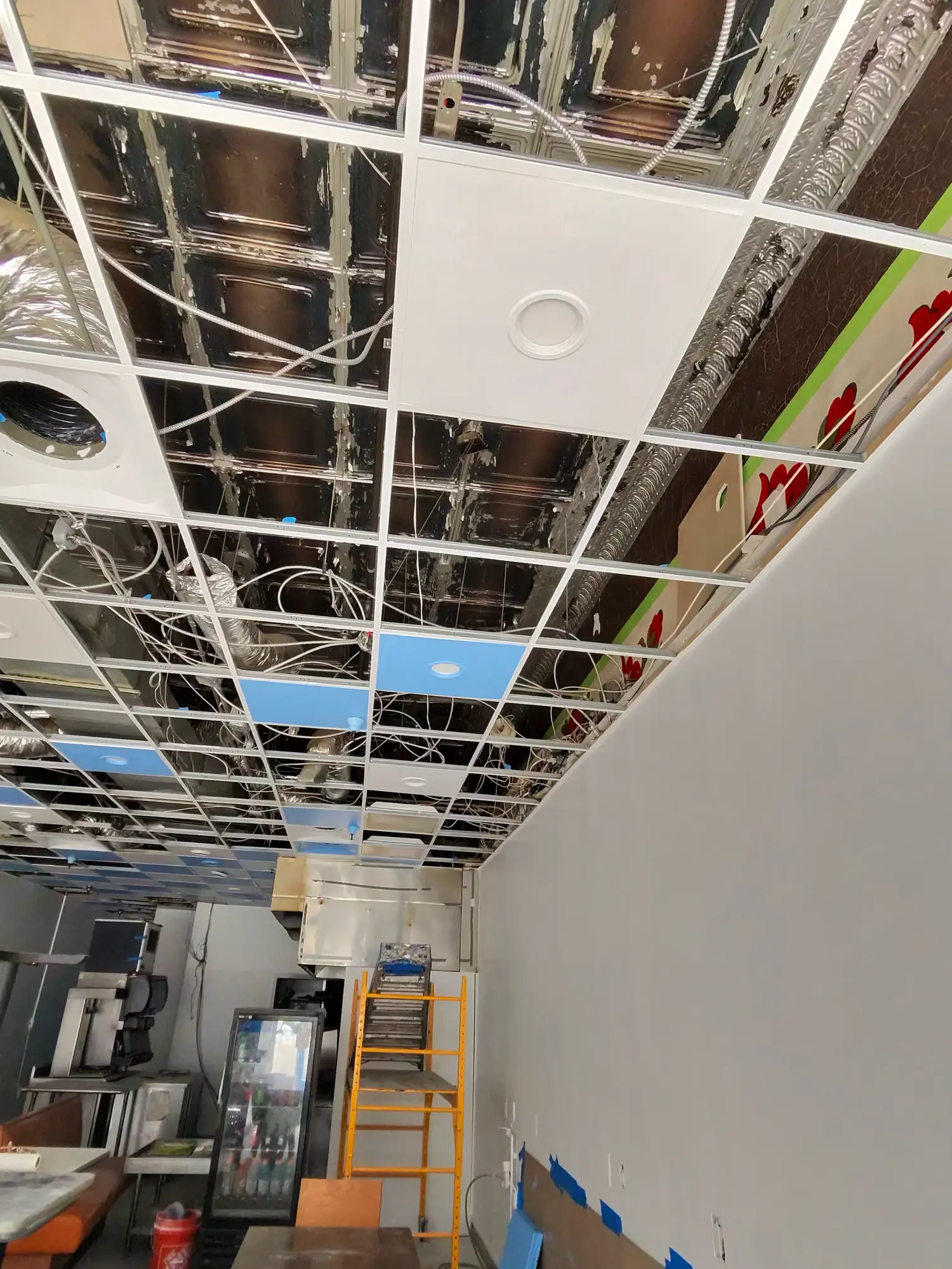 Open restaurant ceiling grid with wiring and ductwork exposed