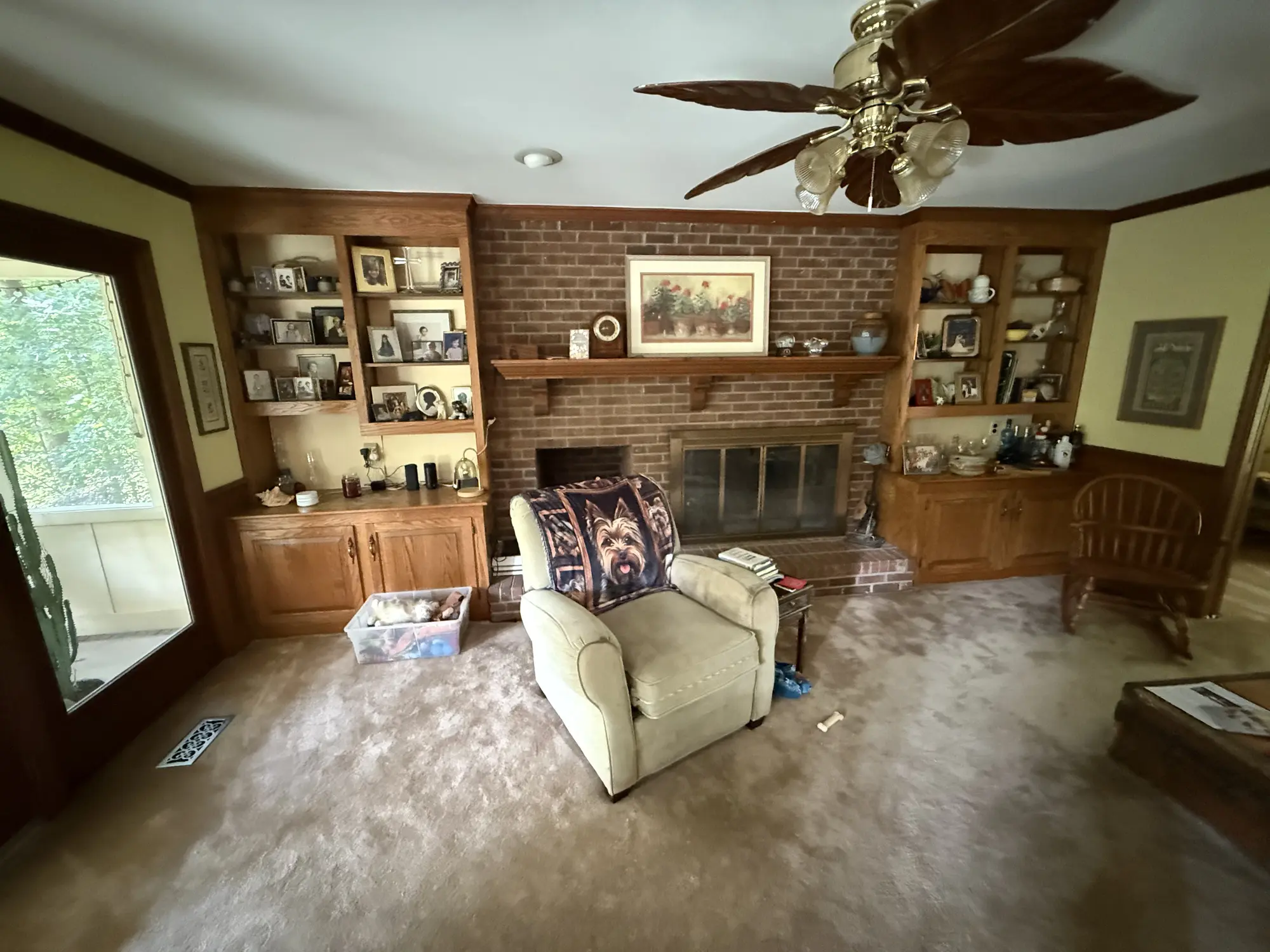 Brick fireplace wall with built-in cabinets before remodel