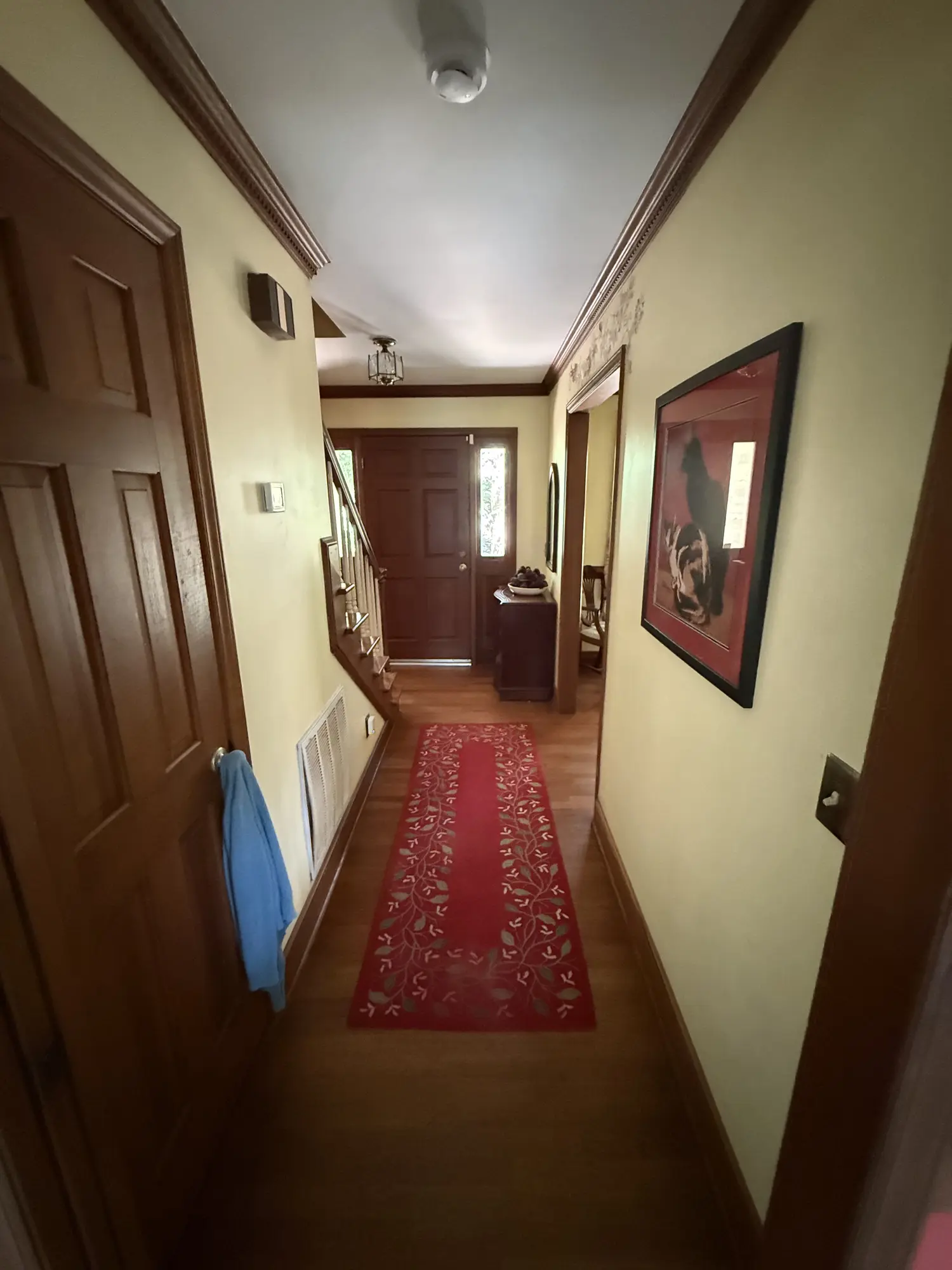 Entry hall with red runner and dated trim before remodel