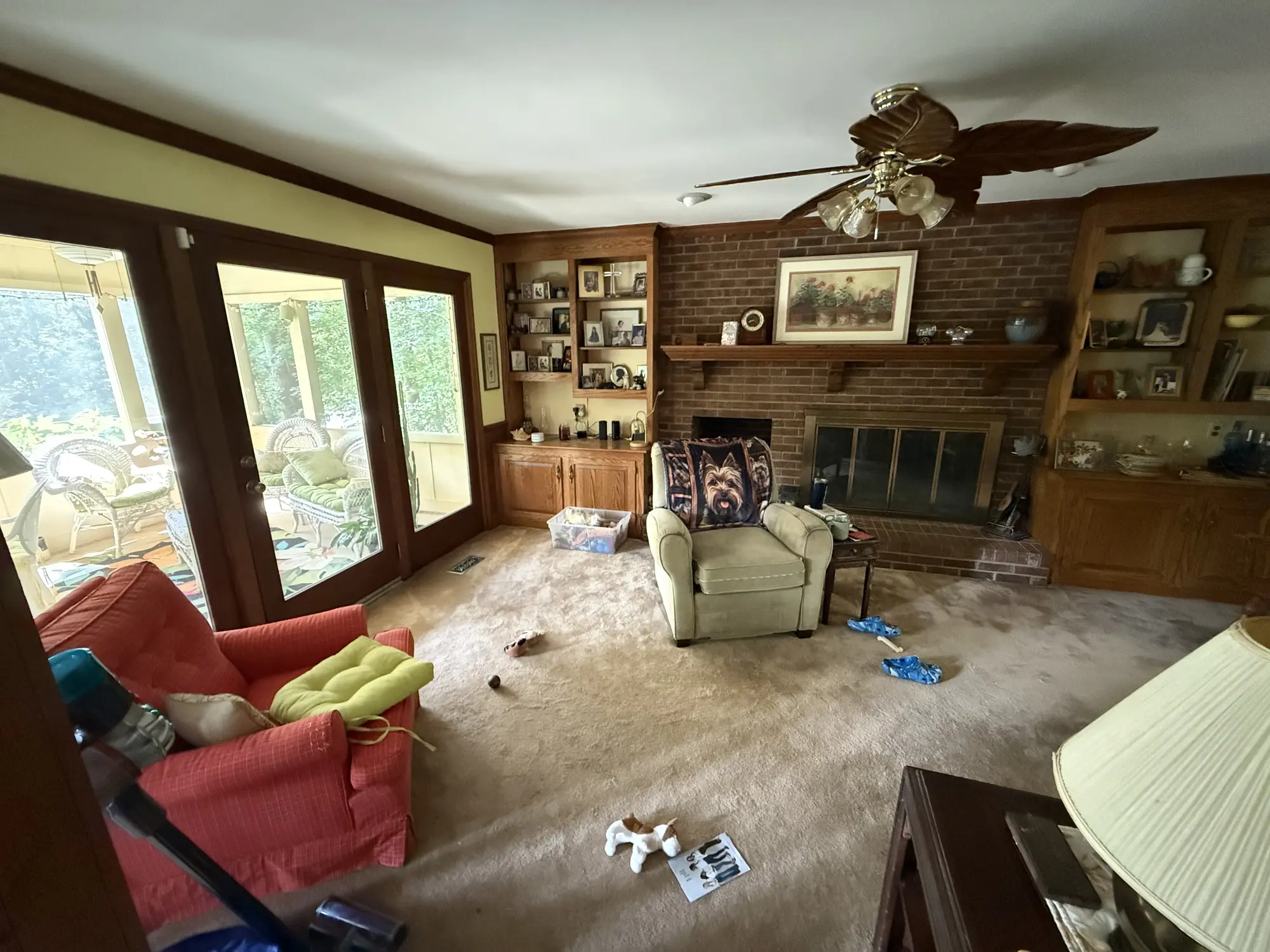 Family room with brick fireplace and old carpet before remodel