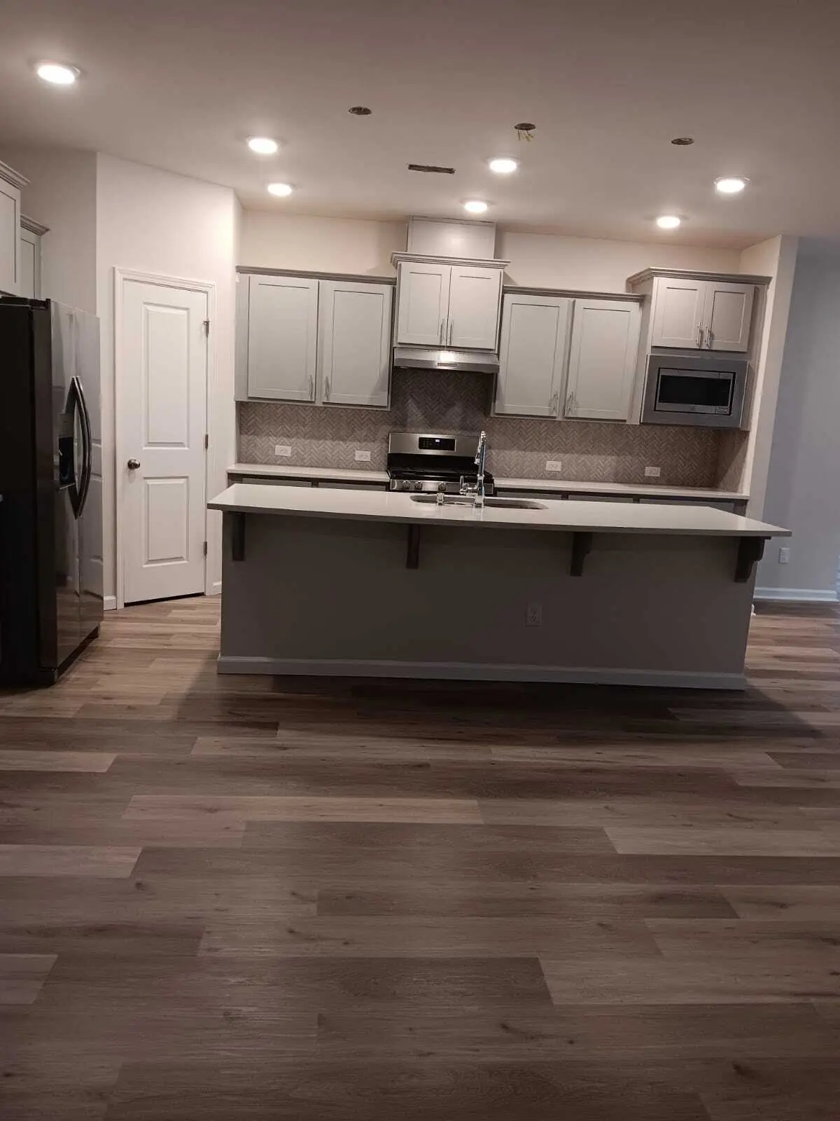 Kitchen island with new luxury vinyl plank flooring around it