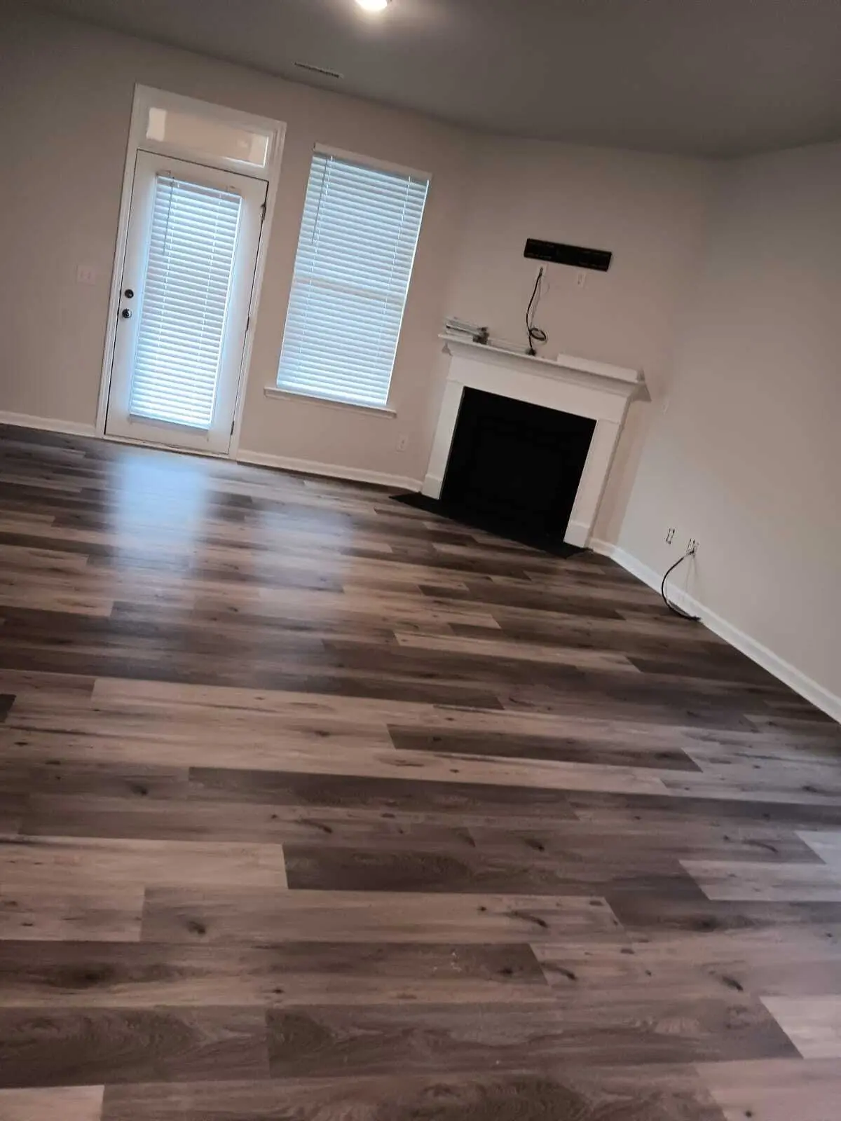 Living room with new luxury vinyl plank flooring and a fireplace, finished and clean