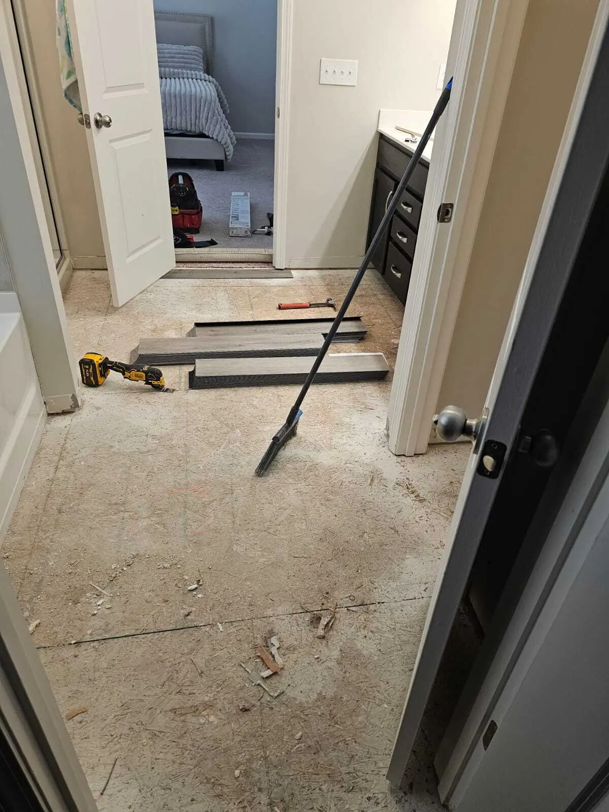 Luxury vinyl plank flooring partway through installation with tools on the subfloor