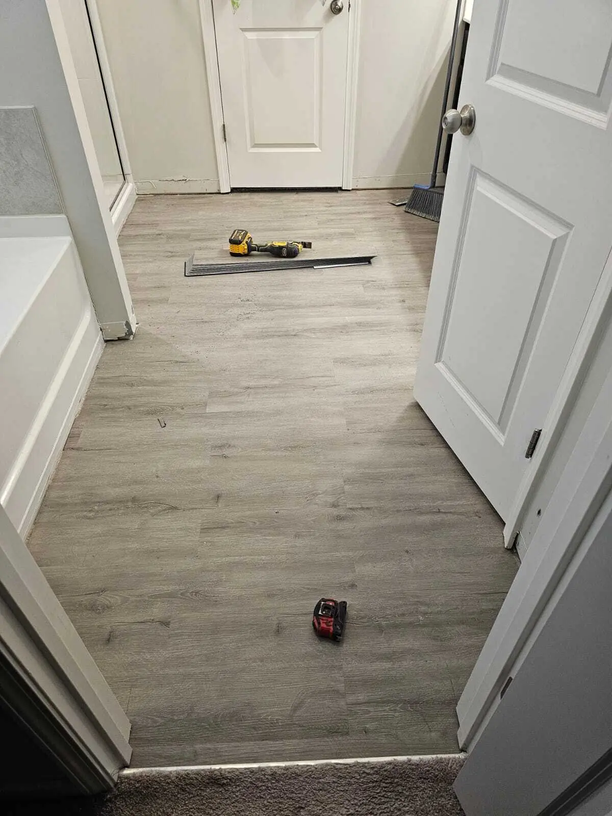 Hallway with new luxury vinyl plank flooring installed through connecting doorways