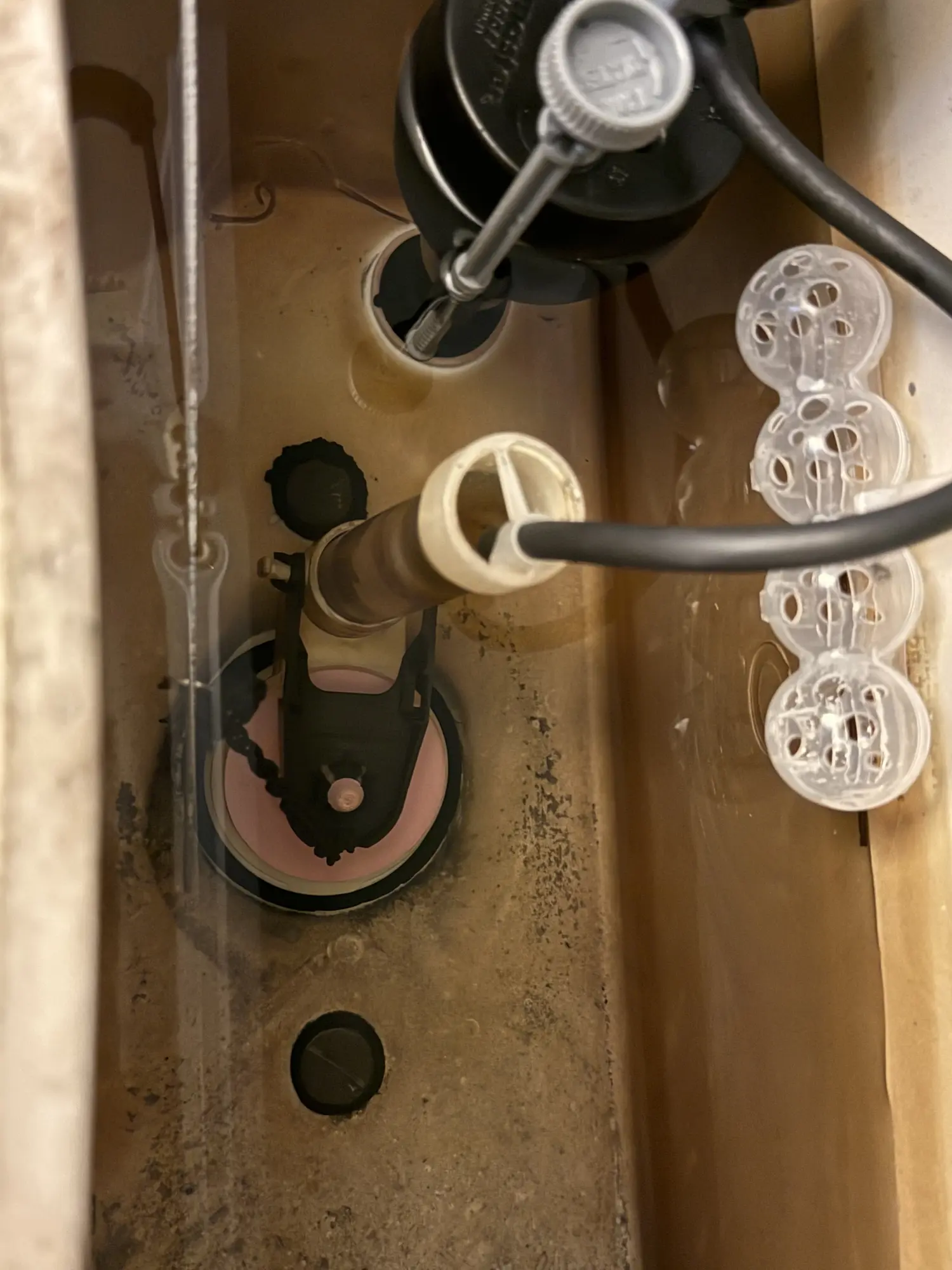 Inside of a toilet tank during a fill valve inspection