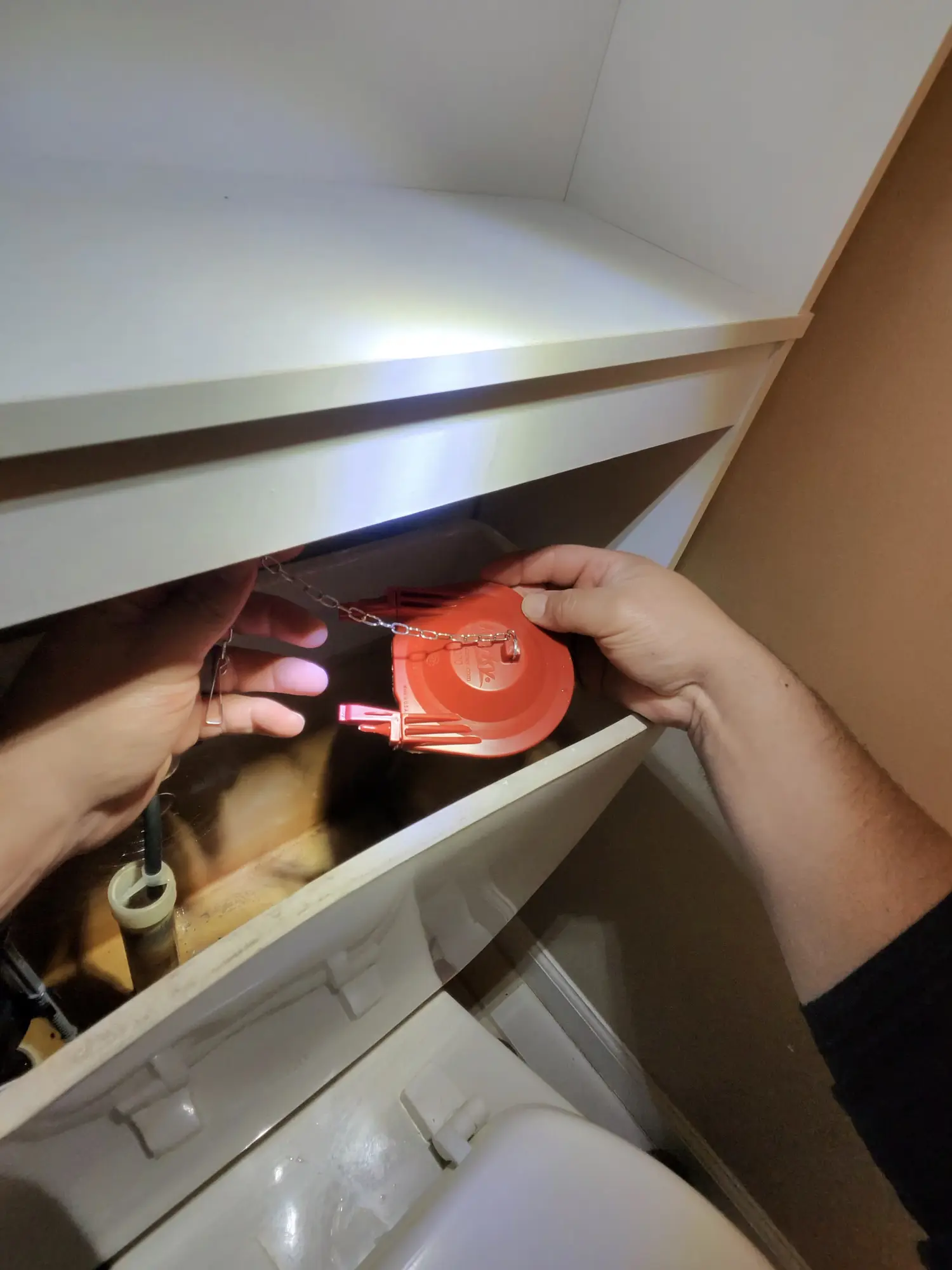 Hand fitting a replacement toilet flapper