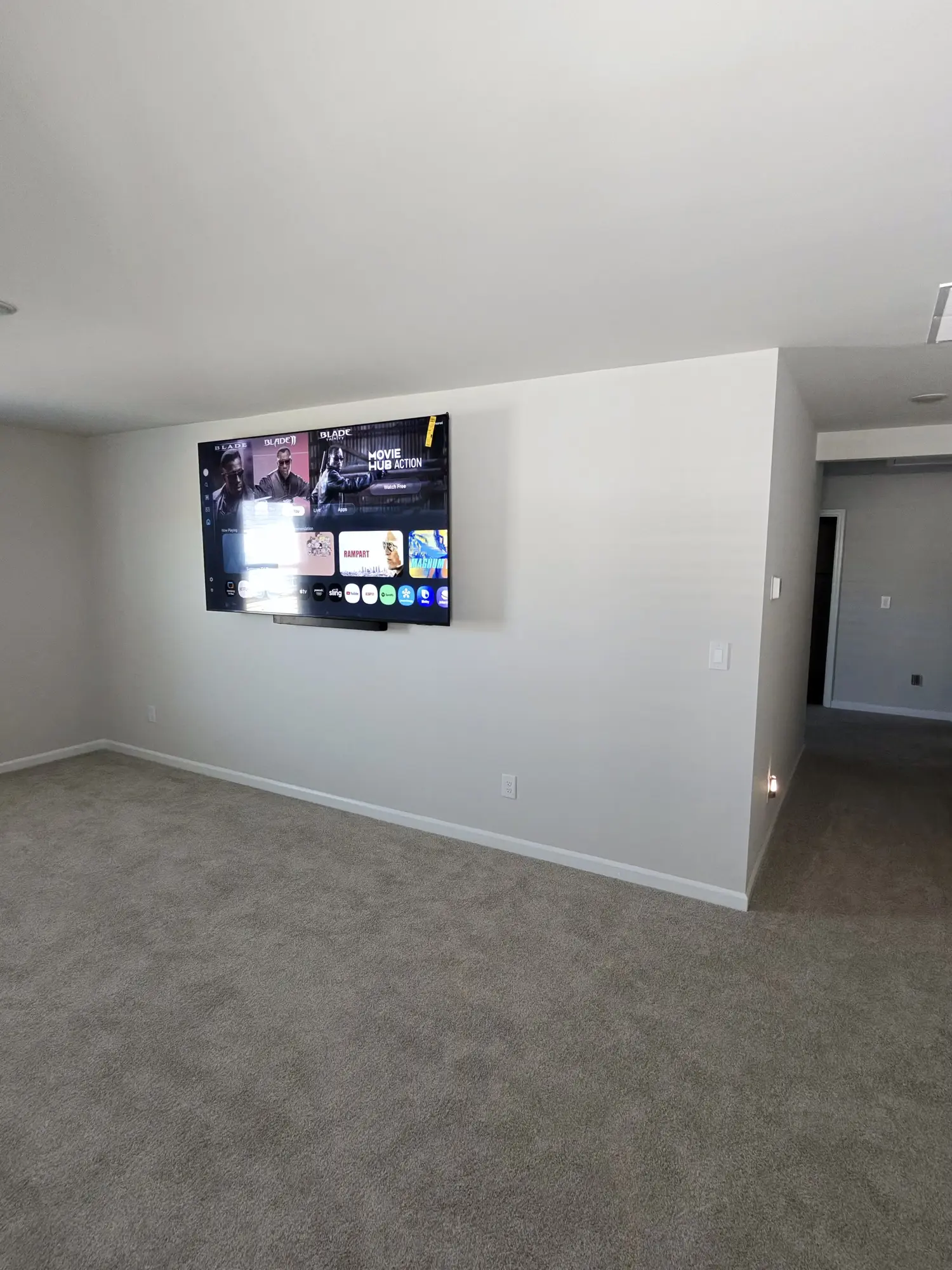 Wall mounted television in a freshly carpeted media room