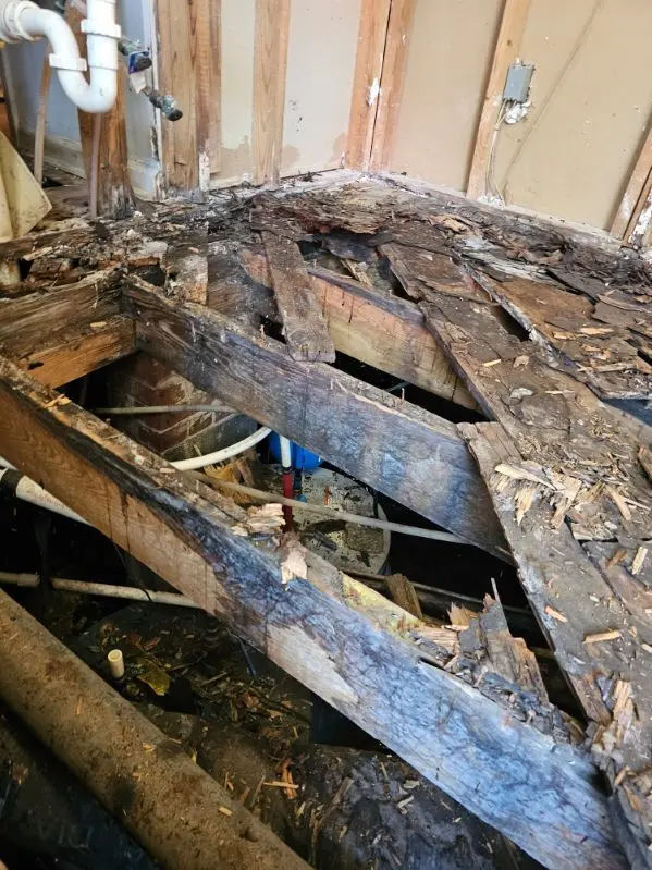 Water damaged wall framing exposed before rebuild