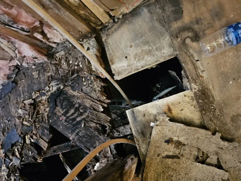 Water damaged floor joists exposed during demolition, before repair